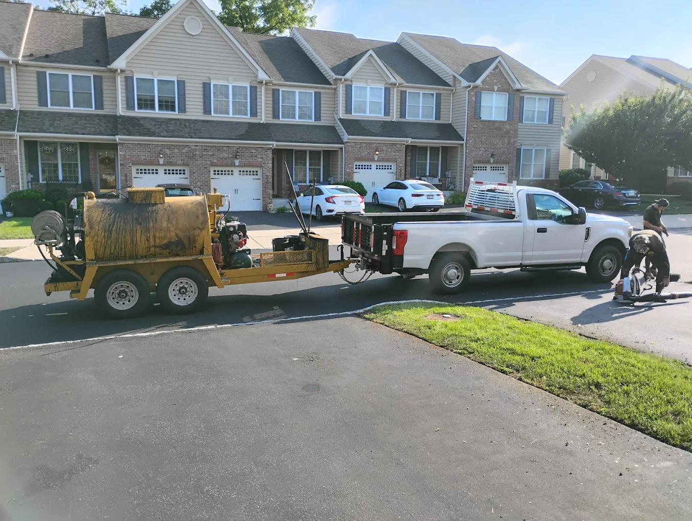 Derek's Sealcoating truck and equipment at a residential job site