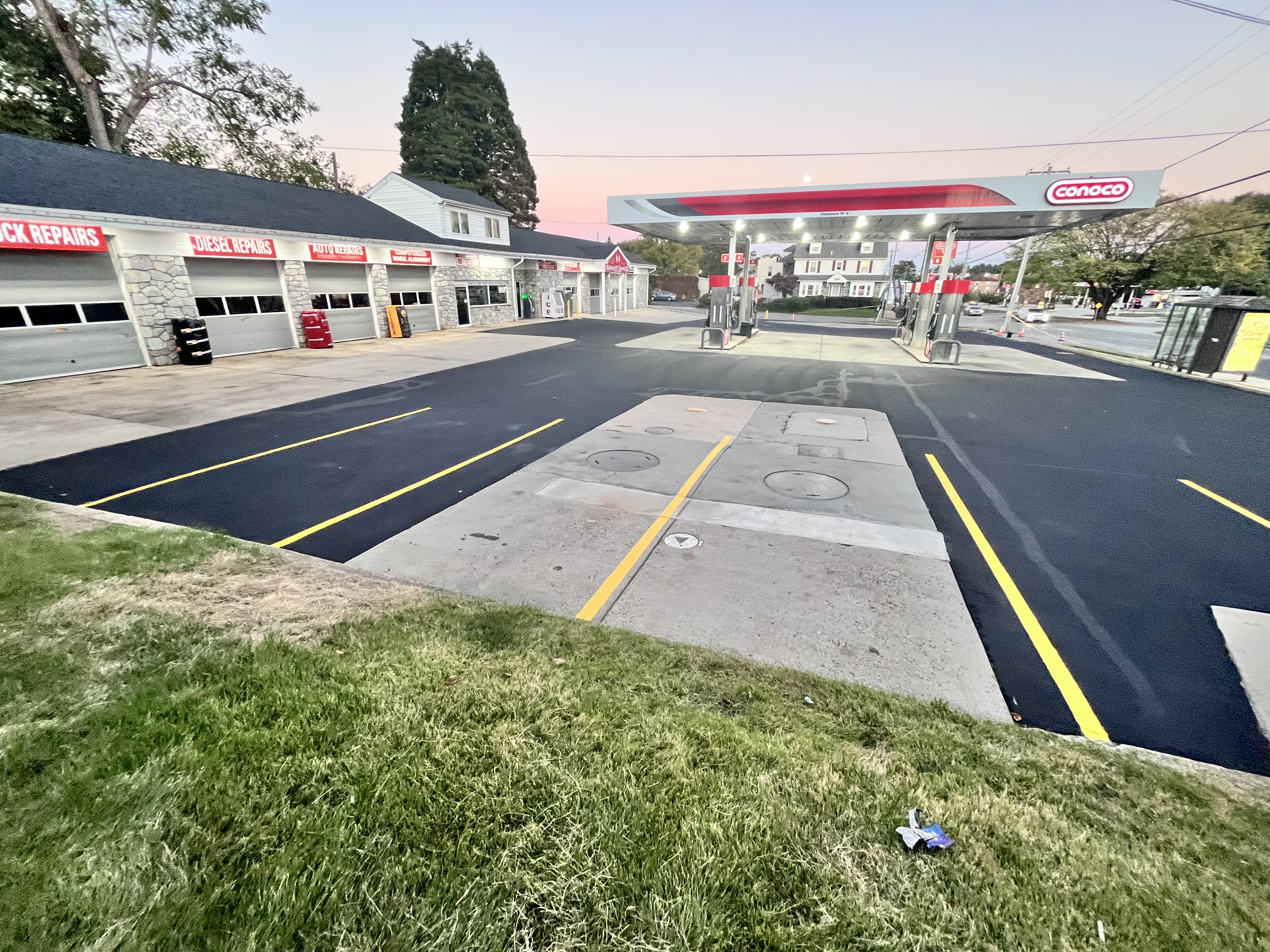 Commercial parking lot with fresh line striping — Conoco station at dusk