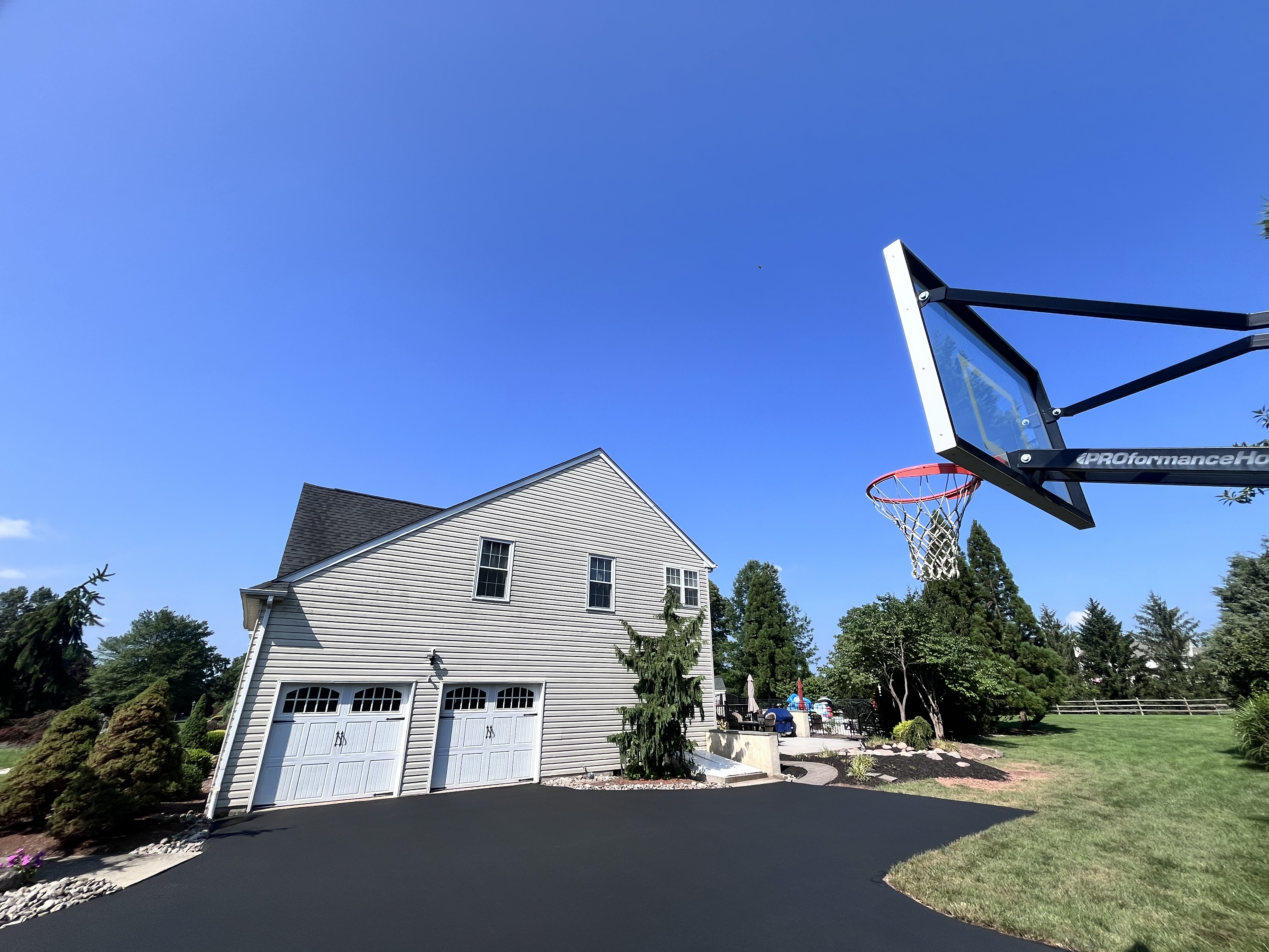 Residential driveway and sport court sealcoating — freshly sealed asphalt